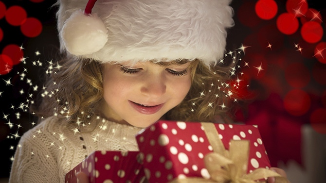 Enfant qui ouvre un cadeau de noel