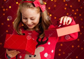 Enfant qui ouvre un cadeau de noel